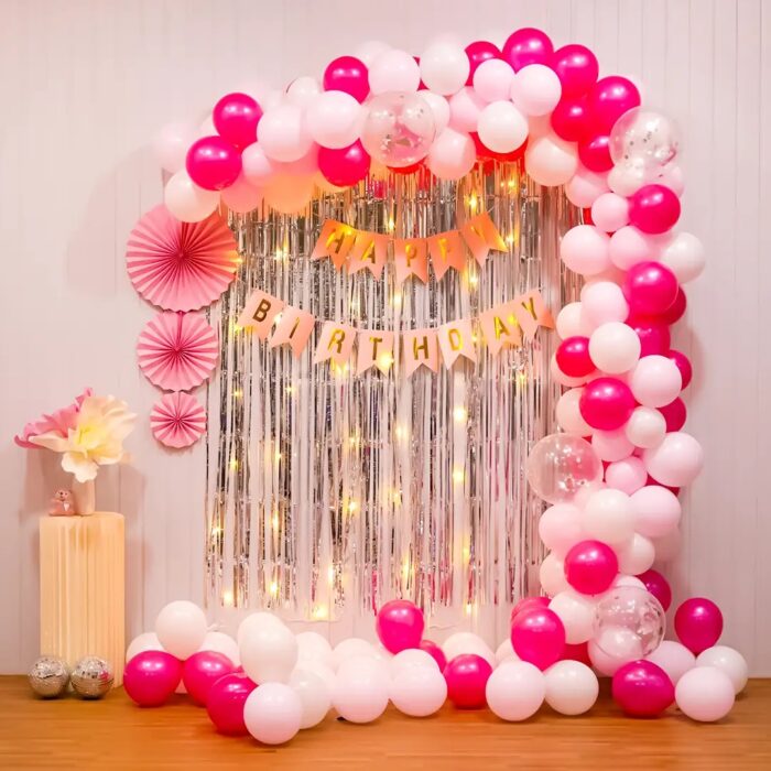 Elegant pink and silver balloon arch for birthday celebration.